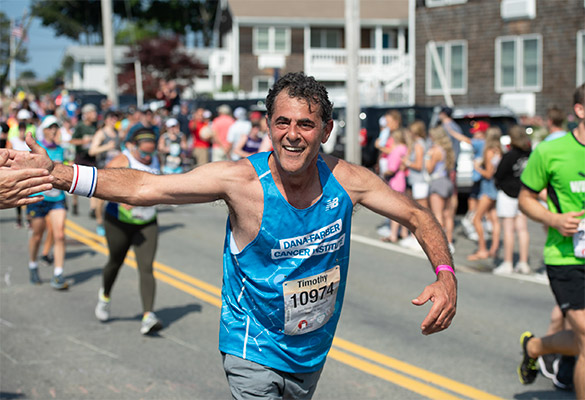 A Falmouth Road Race runner receives a high-five from a spectator