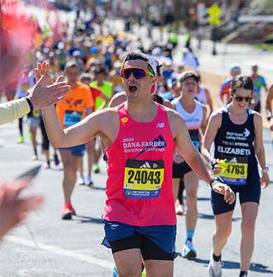 A Dana-Farber Marathon Challenge runner receives a high five from a supporter