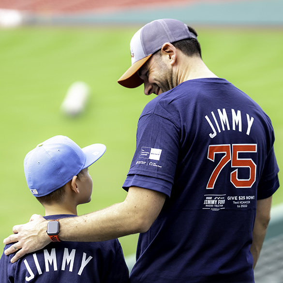 A father and son exchange a smile while looking out over Fenway Park