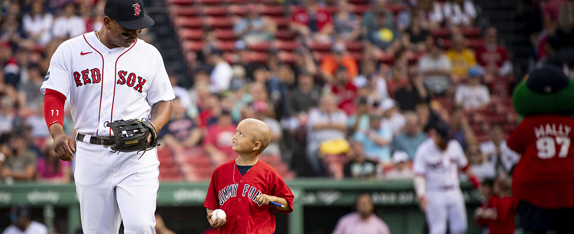 A pediatric Dana-Farber patient enjoys a moment on the field at Fenway with Red Sox player Rafael Devers