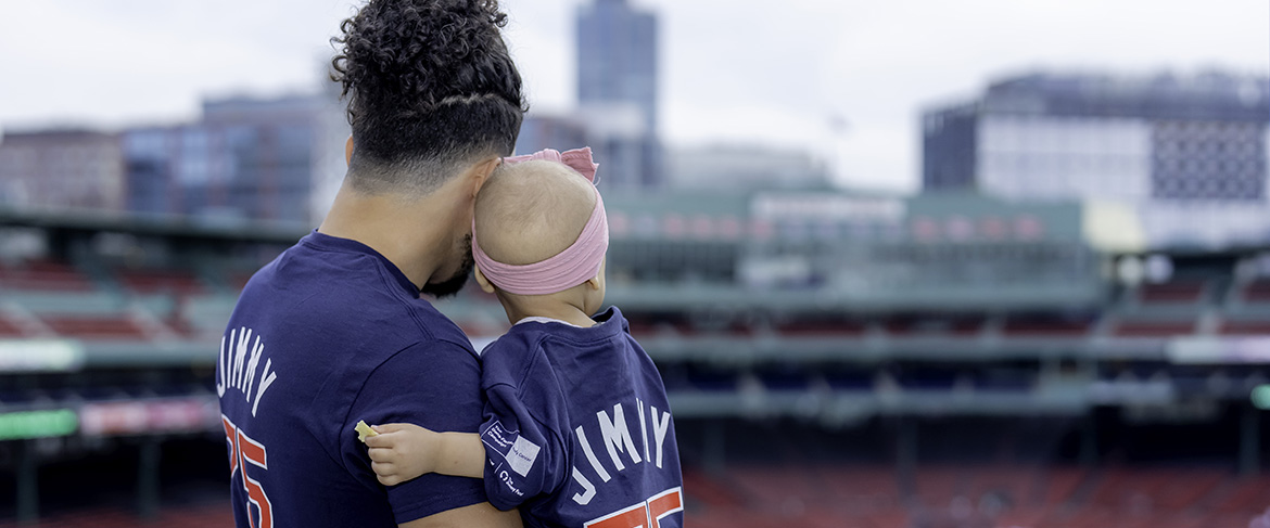 A father holds his daughter, a Dana-Farber patient, at Fenway Park