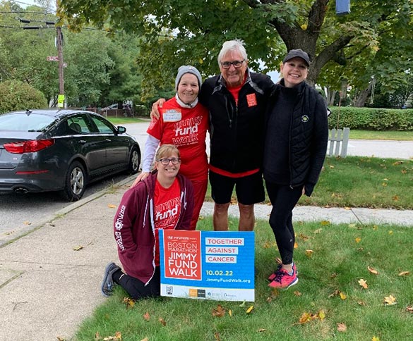 Four Jimmy Fund Walk participants pose for a photo with a Walk sign