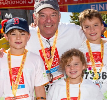 John and three of his grandchildren at the finish line of the Boston Marathon in 2015. 