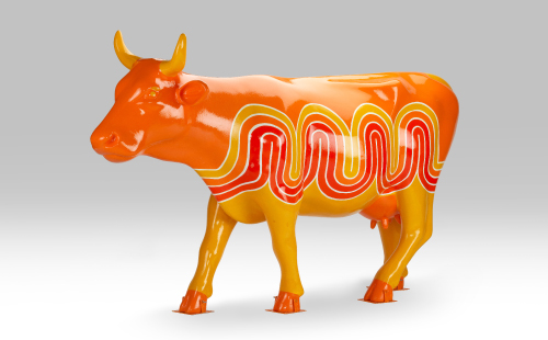 Orange and red cow facing left