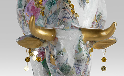 Cow covered in various currency close-up