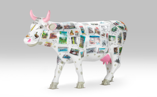 Pink and white cow with stamps facing left
