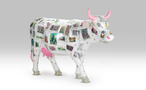 Pink and white cow with stamps facing right