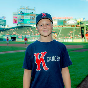 A Jimmy Fund Clinic patient at Fenway wearing a 'K Cancer' shirt