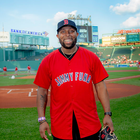 A Dana-Farber patient stands on the field at Fenway Park