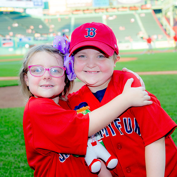 Two young Jimmy Fund Clinic patients hug at Fenway Park