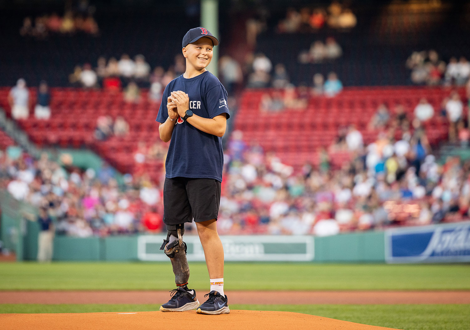 Young Dana-Farber patient preparing to throw a baseball at Fenway Park
