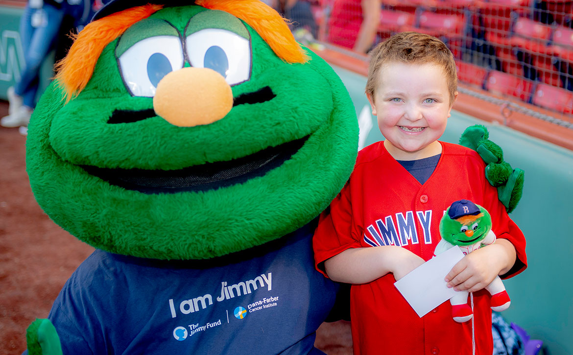 Jimmy Fund Clinic patient, Sydney, with Wally the Green Monster at Fenway Park